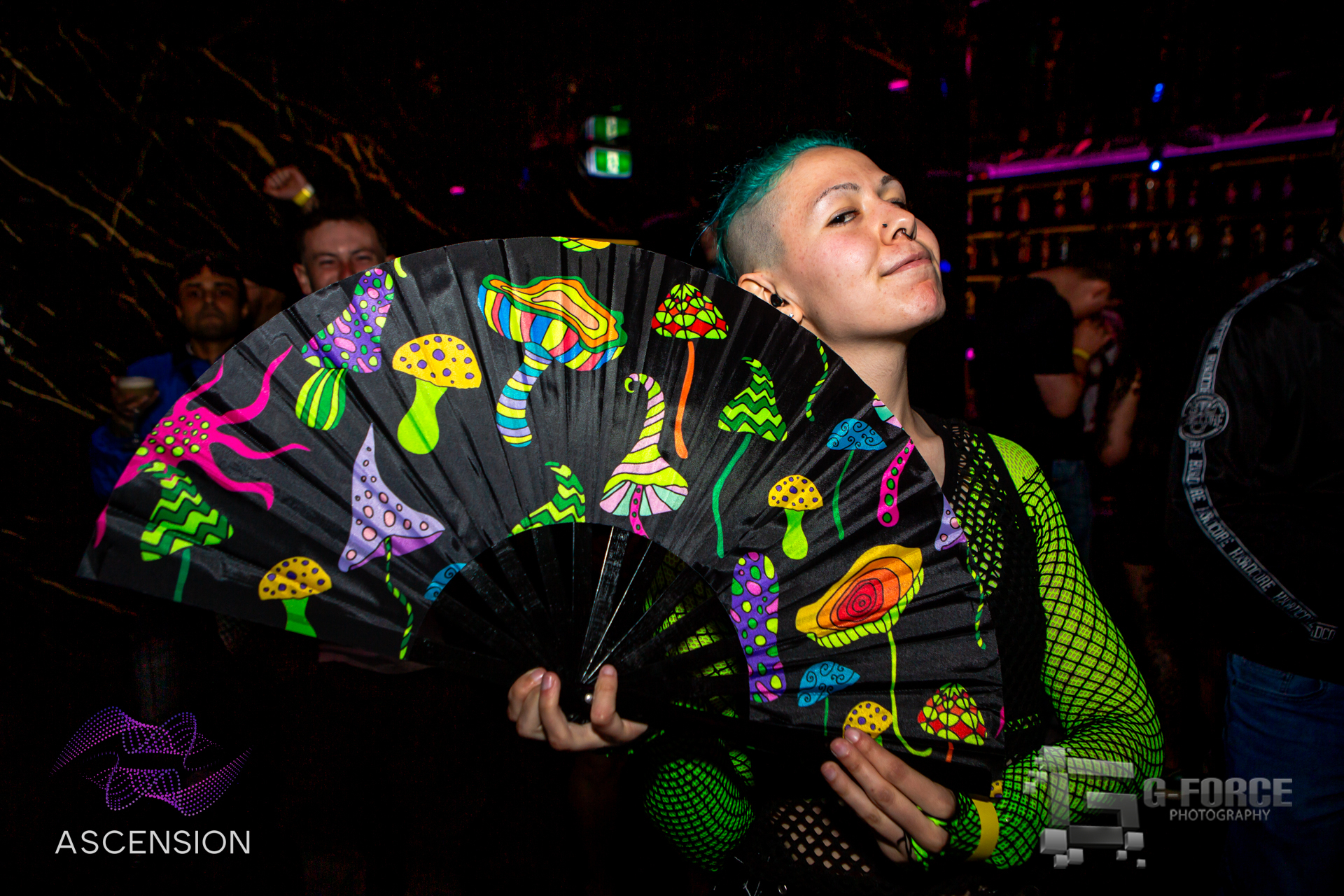 Rave attendee with psychedelic mushroom fan under club lights
